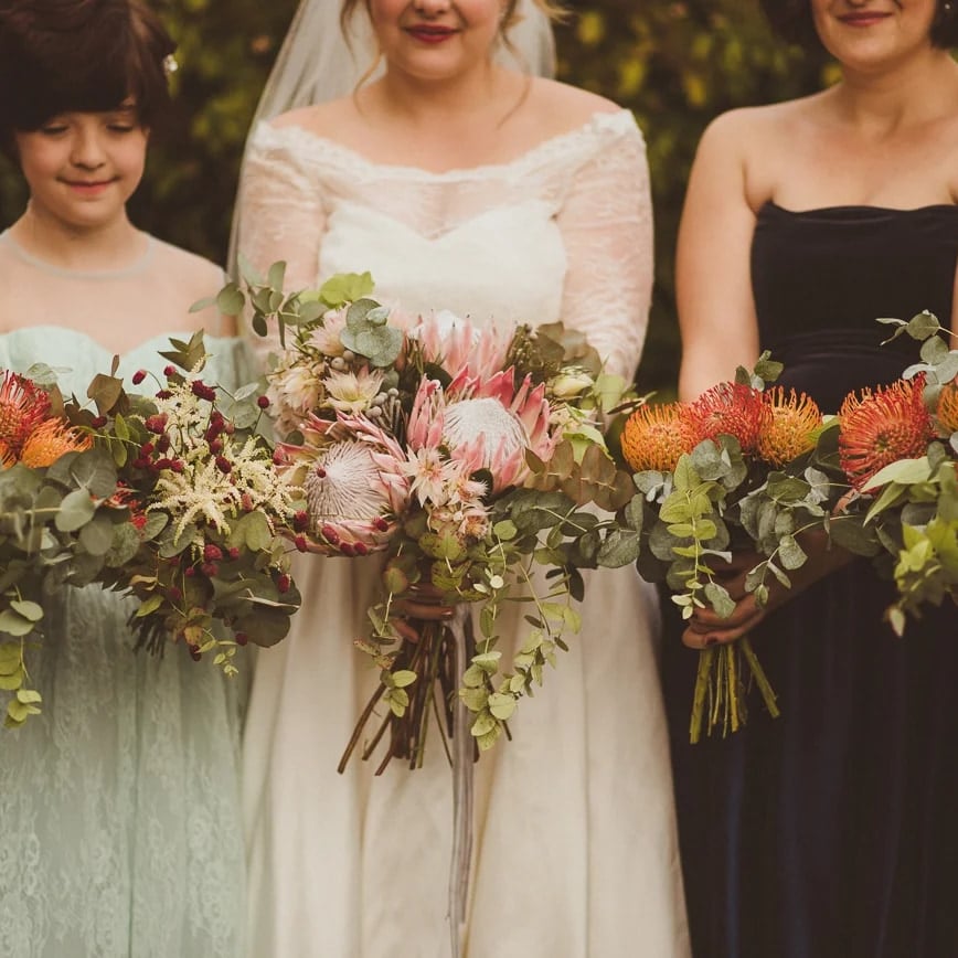 Bridal party holding protea and pincushion bouquets