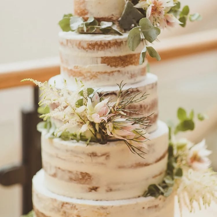 Naked wedding cake styled with fresh flowers