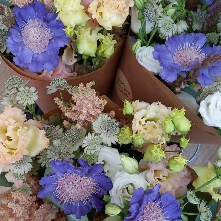 Top-down view of pastel Friday Flowers bunches wrapped in kraft paper
